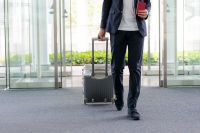 Foto: Mann mit Koffer am Flughafen